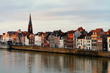 La guglia del campanile spicca in mezzo agli altri palazzi bianchi della città di Maastricht