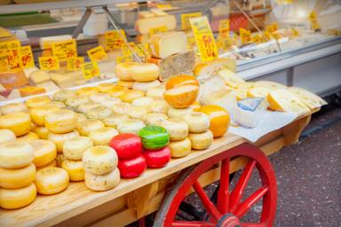 Selezione di formaggi posti su un banco con le ruote di legno rosse